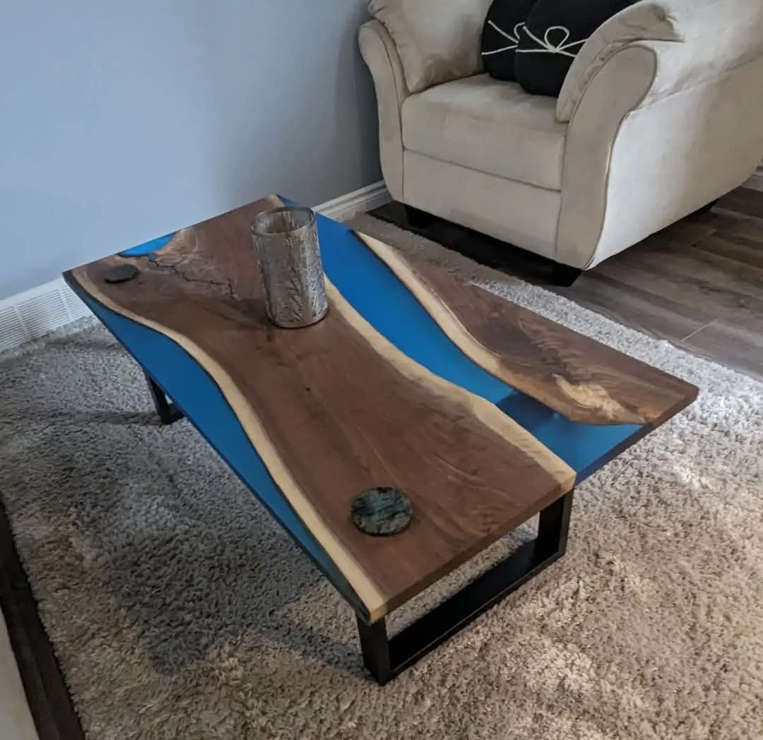 Live edge walnut blue epoxy river coffee table with black U-base on shag rug
