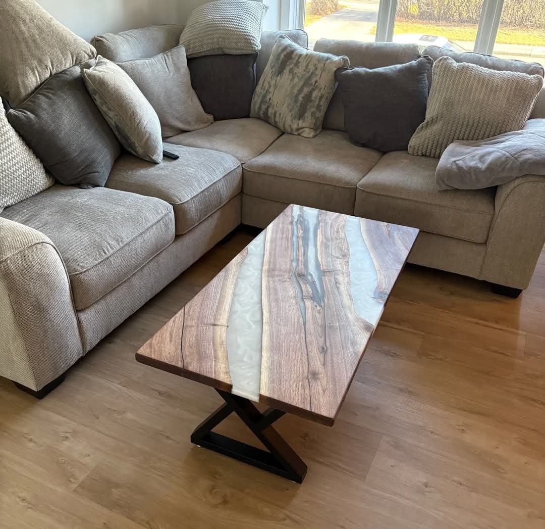 Live edge walnut grey epoxy river coffee table with black Z-base beside sectional sofa