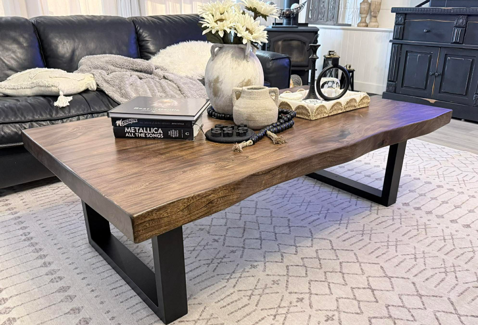 Live edge walnut coffee table with black U-base styled with Metallica book and farmhouse decor