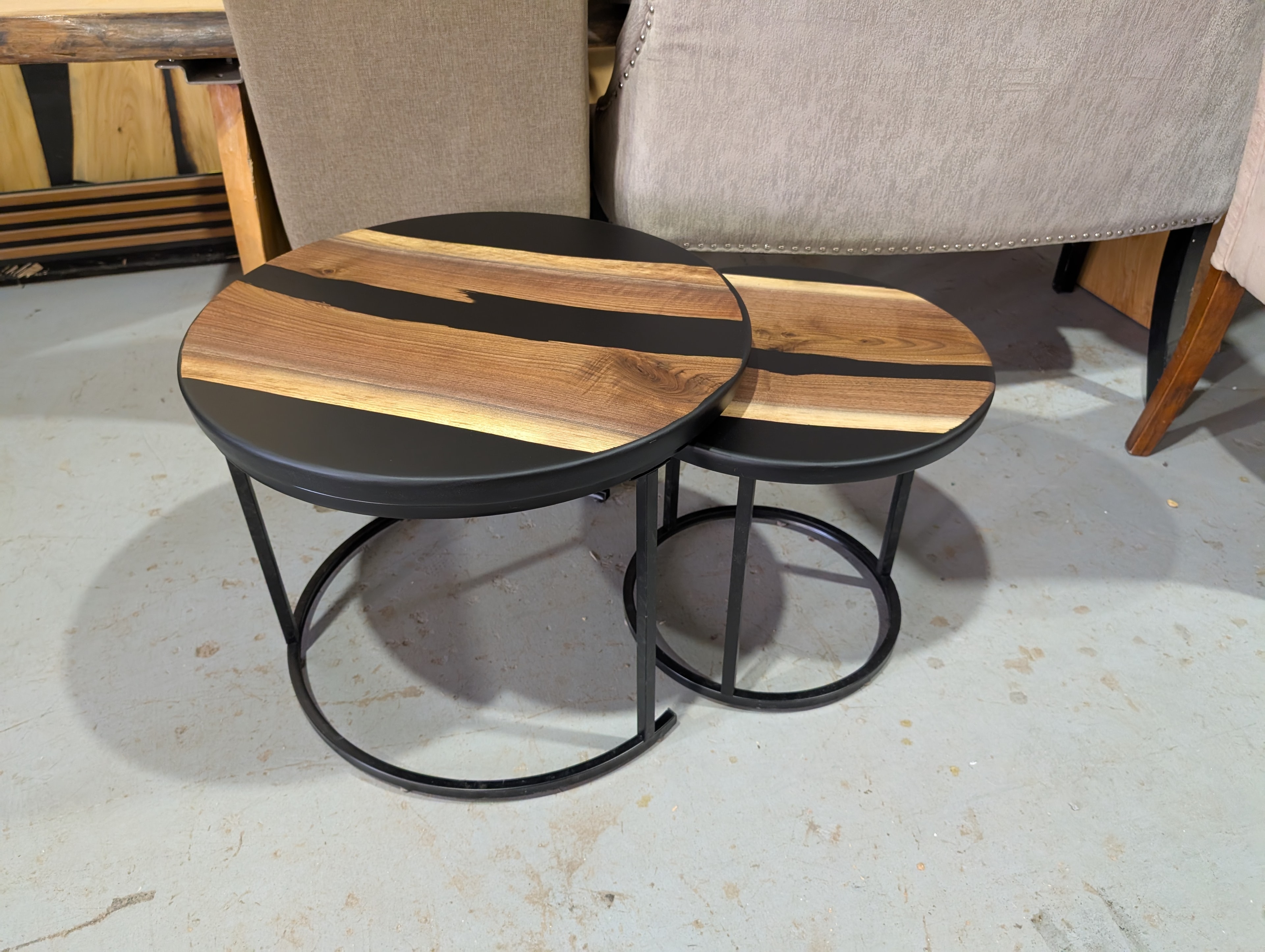 Round walnut black epoxy nesting coffee table set — shop display side view