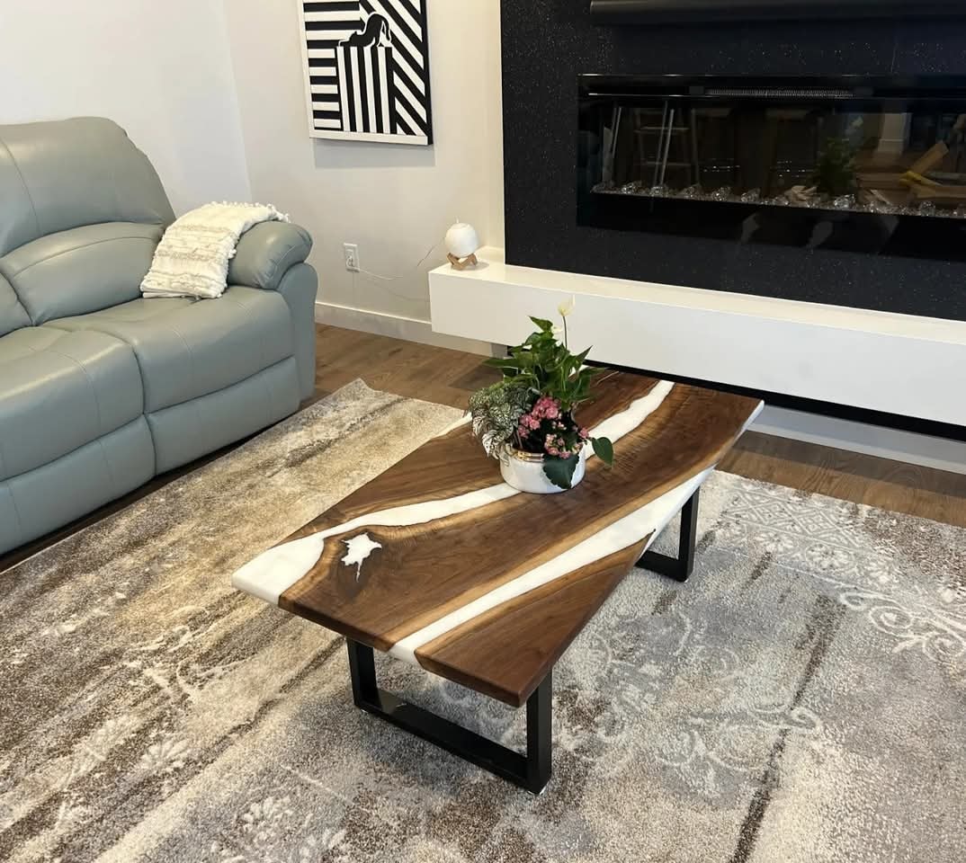 Live edge walnut white epoxy river coffee table with black U-base beside modern fireplace