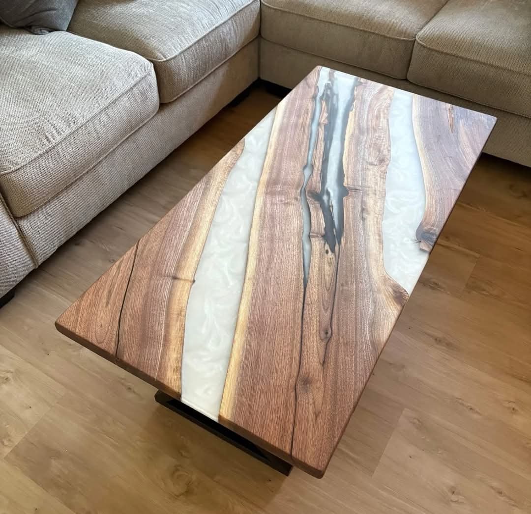 Live edge walnut white epoxy river coffee table with black U-base beside beige sectional sofa