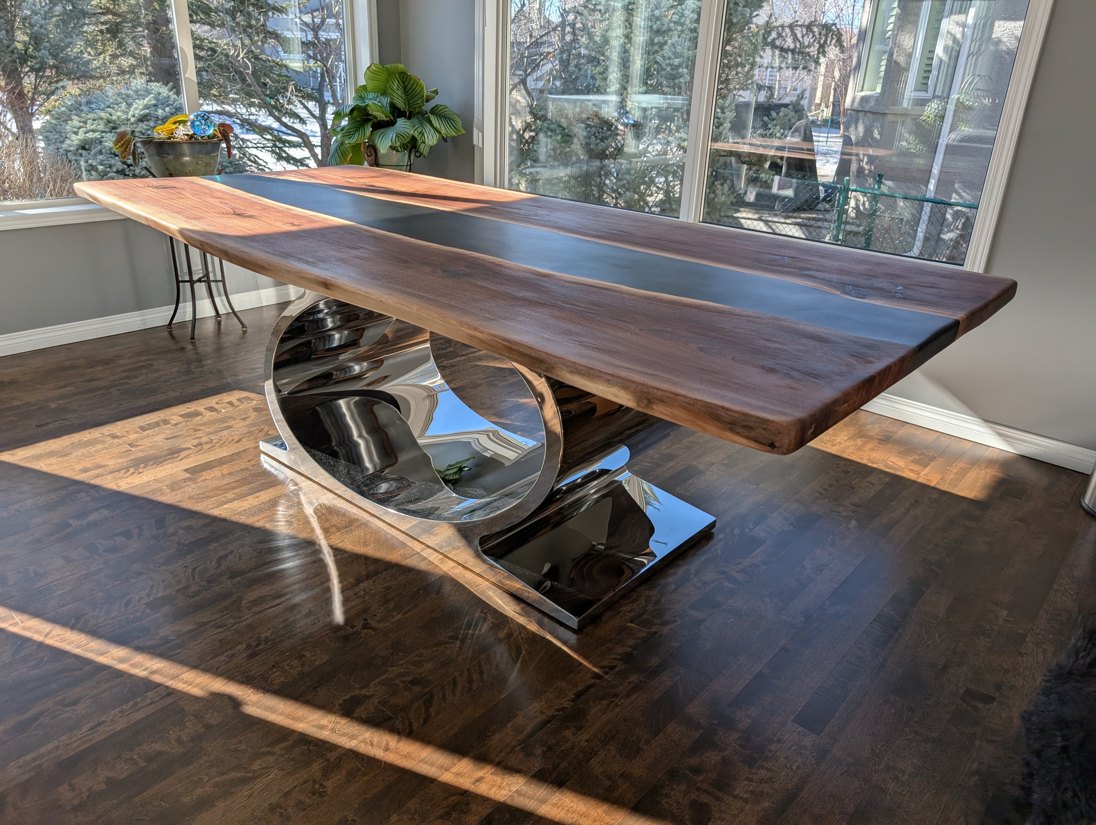 Black epoxy river walnut dining table with sculptural chrome base
