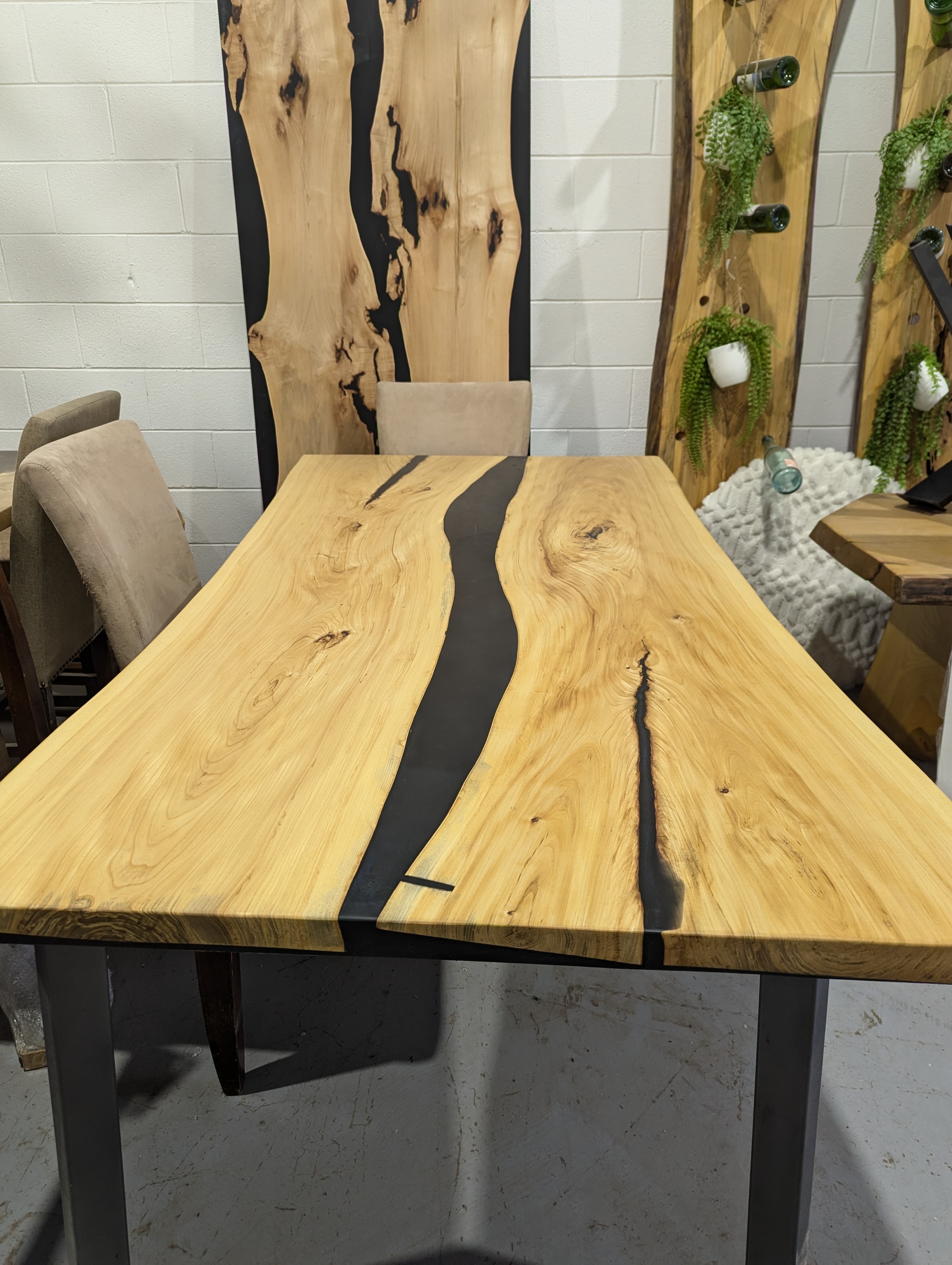 Black epoxy river elm dining table on display in Calgary Wood Works showroom