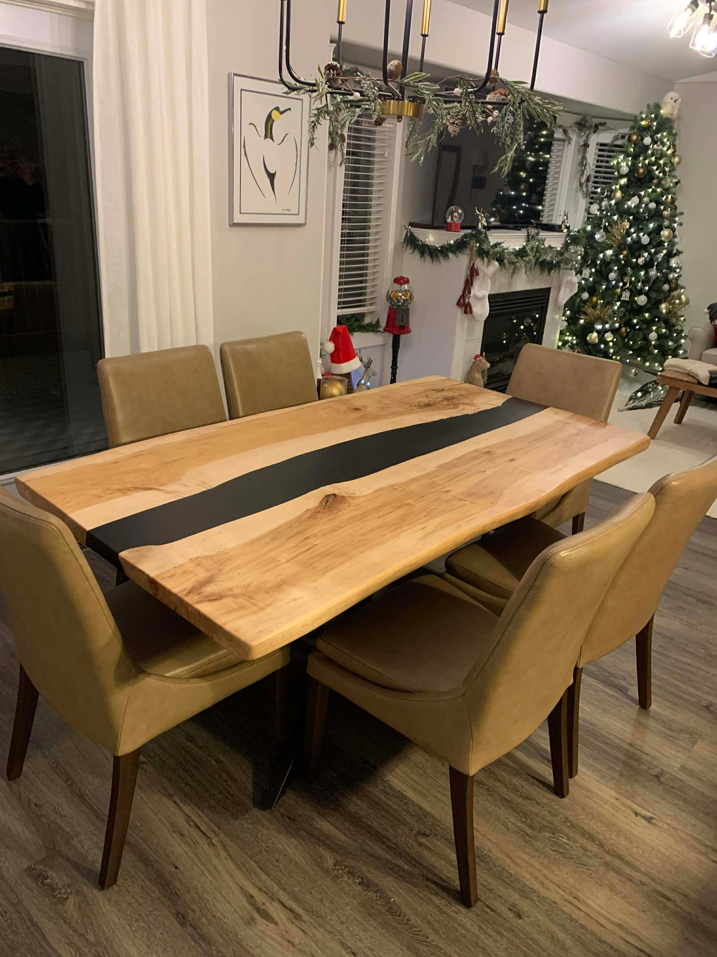 Live edge maple black epoxy river dining table with gold leather chairs at Christmas