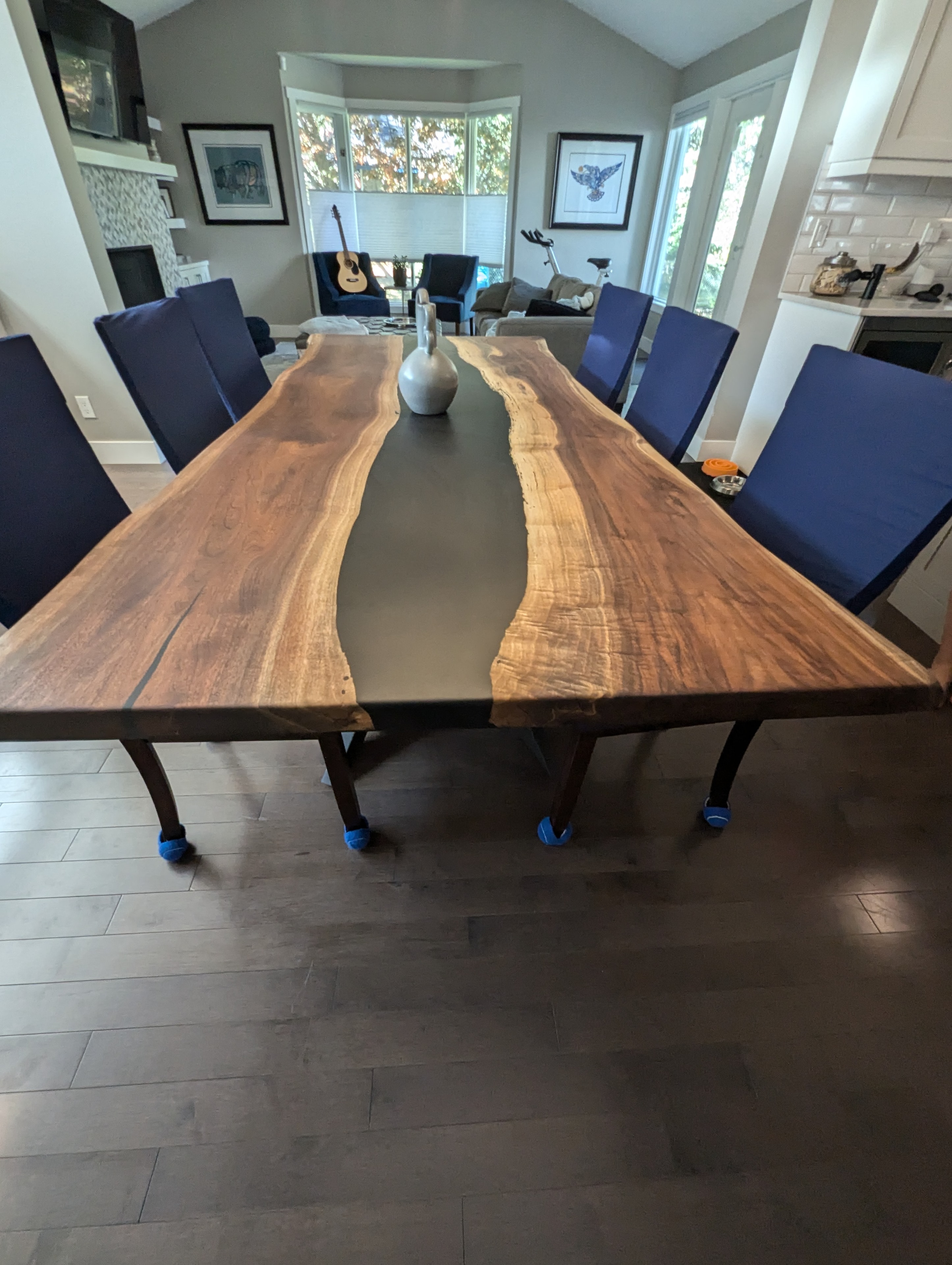 Black epoxy river walnut dining table with navy upholstered chairs