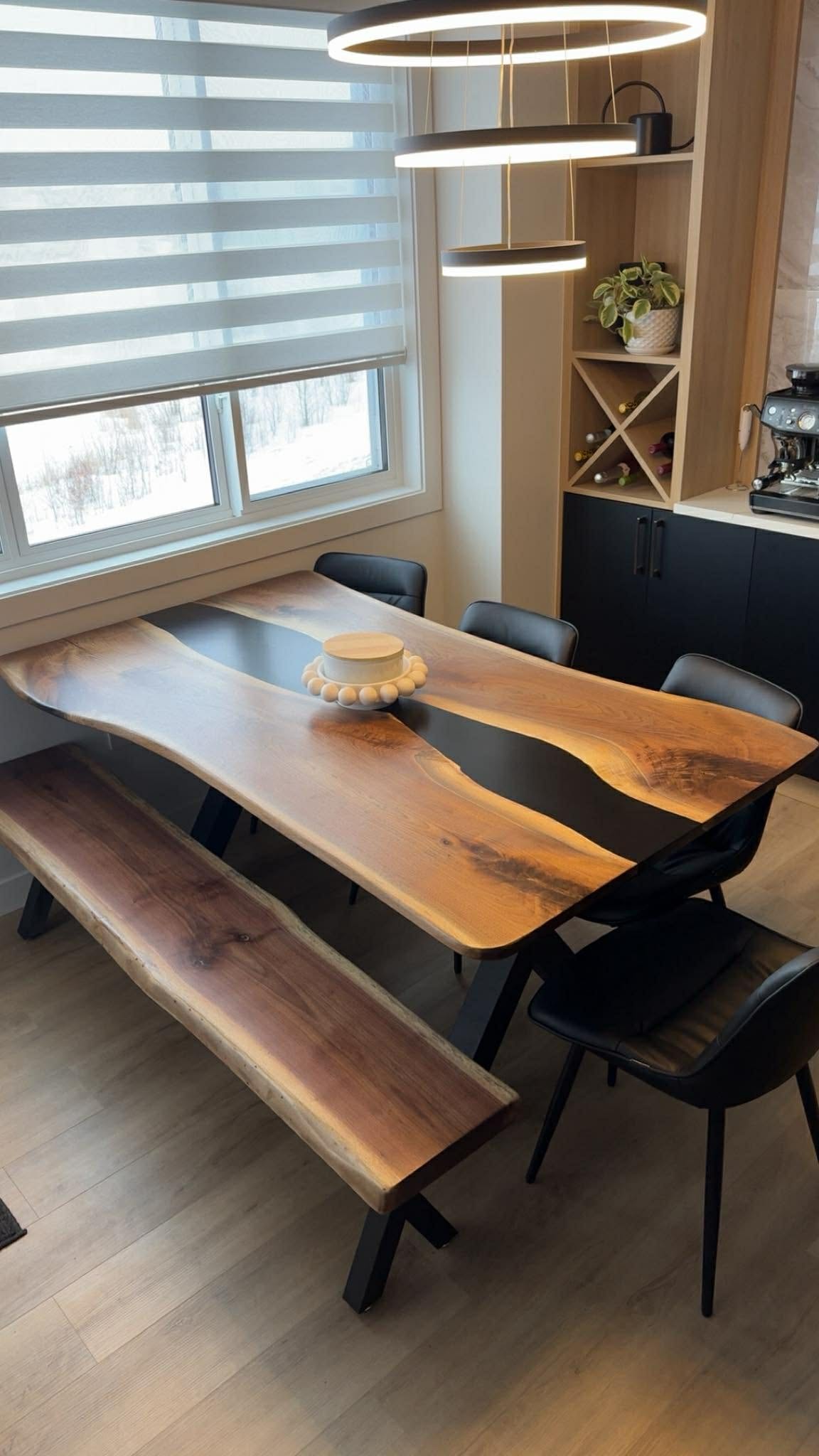 Live edge walnut black epoxy river dining table with matching bench under ring pendant