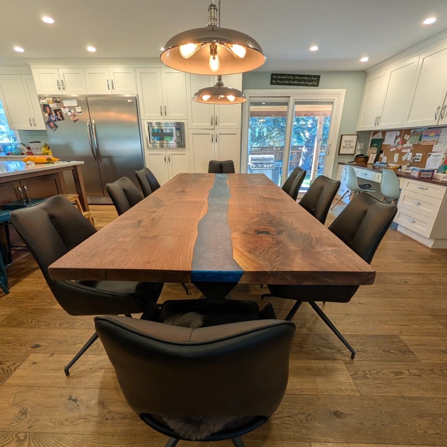 Live edge walnut black epoxy river dining table seating 10 under industrial pendant