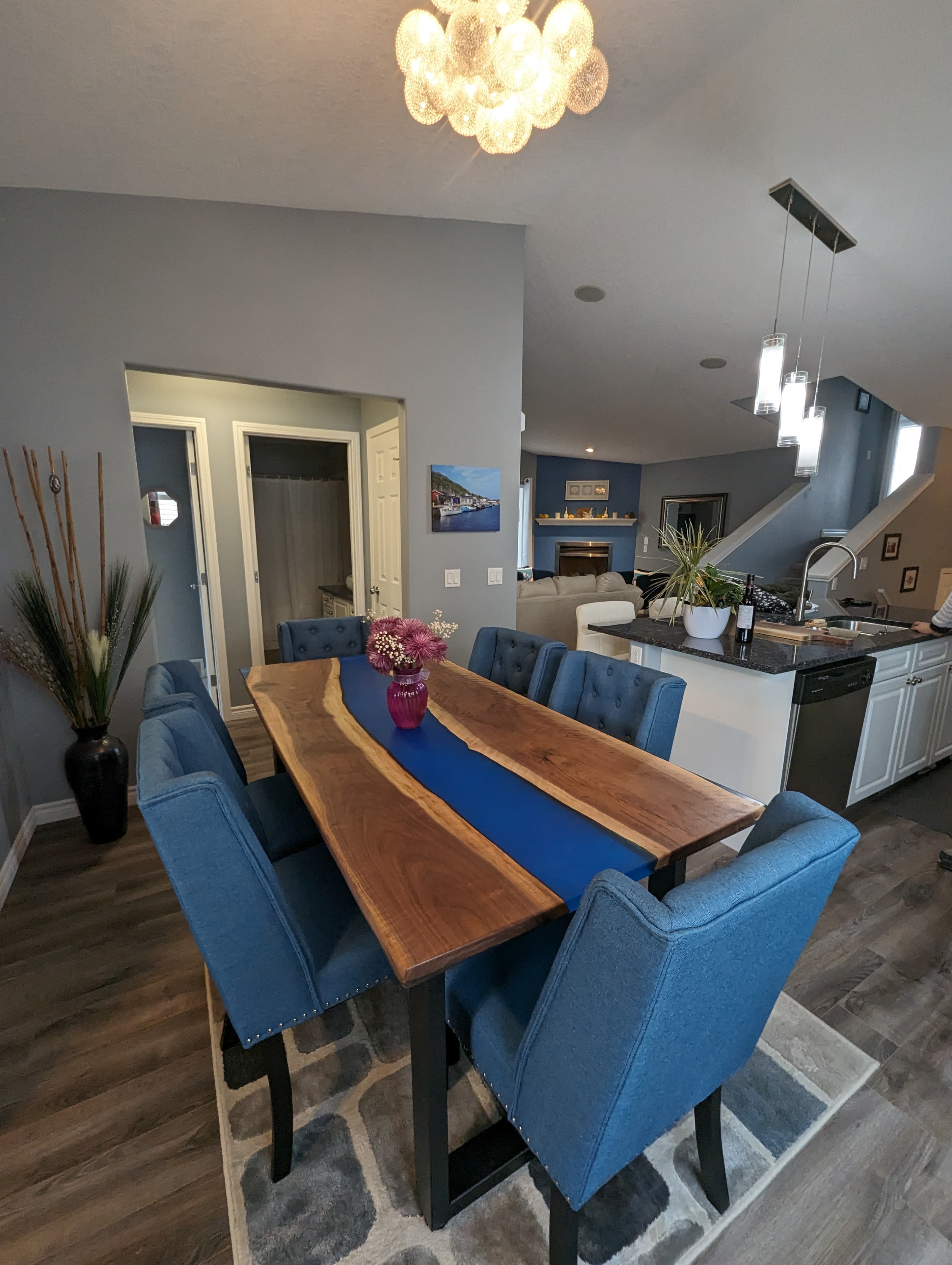 Live edge walnut blue epoxy river dining table with matching blue tufted chairs