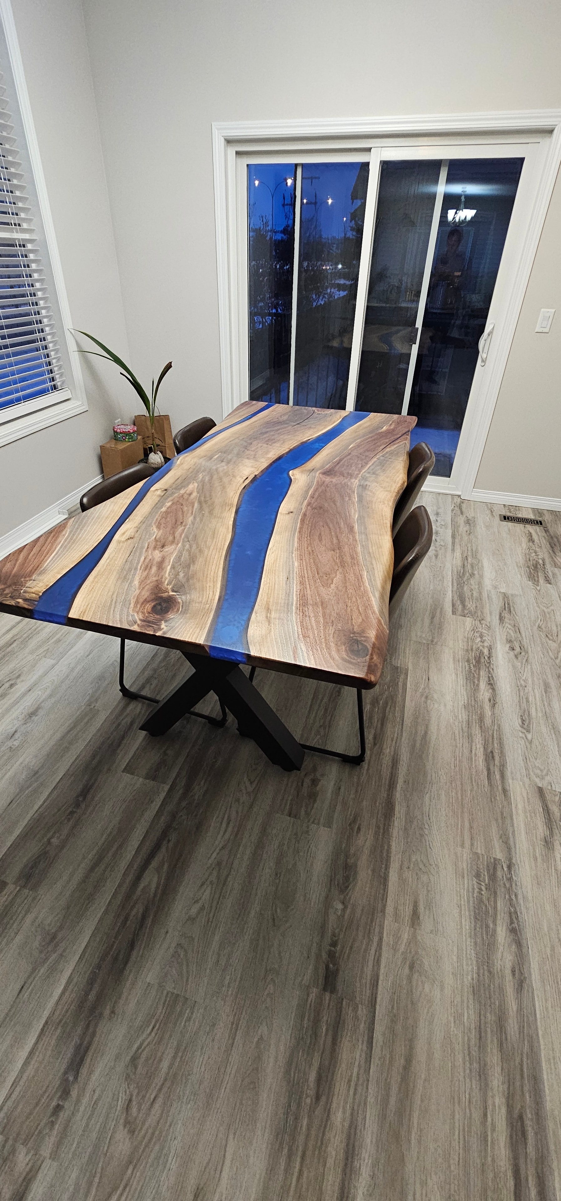 Blue epoxy river walnut dining table displayed upright in Calgary Wood Works shop