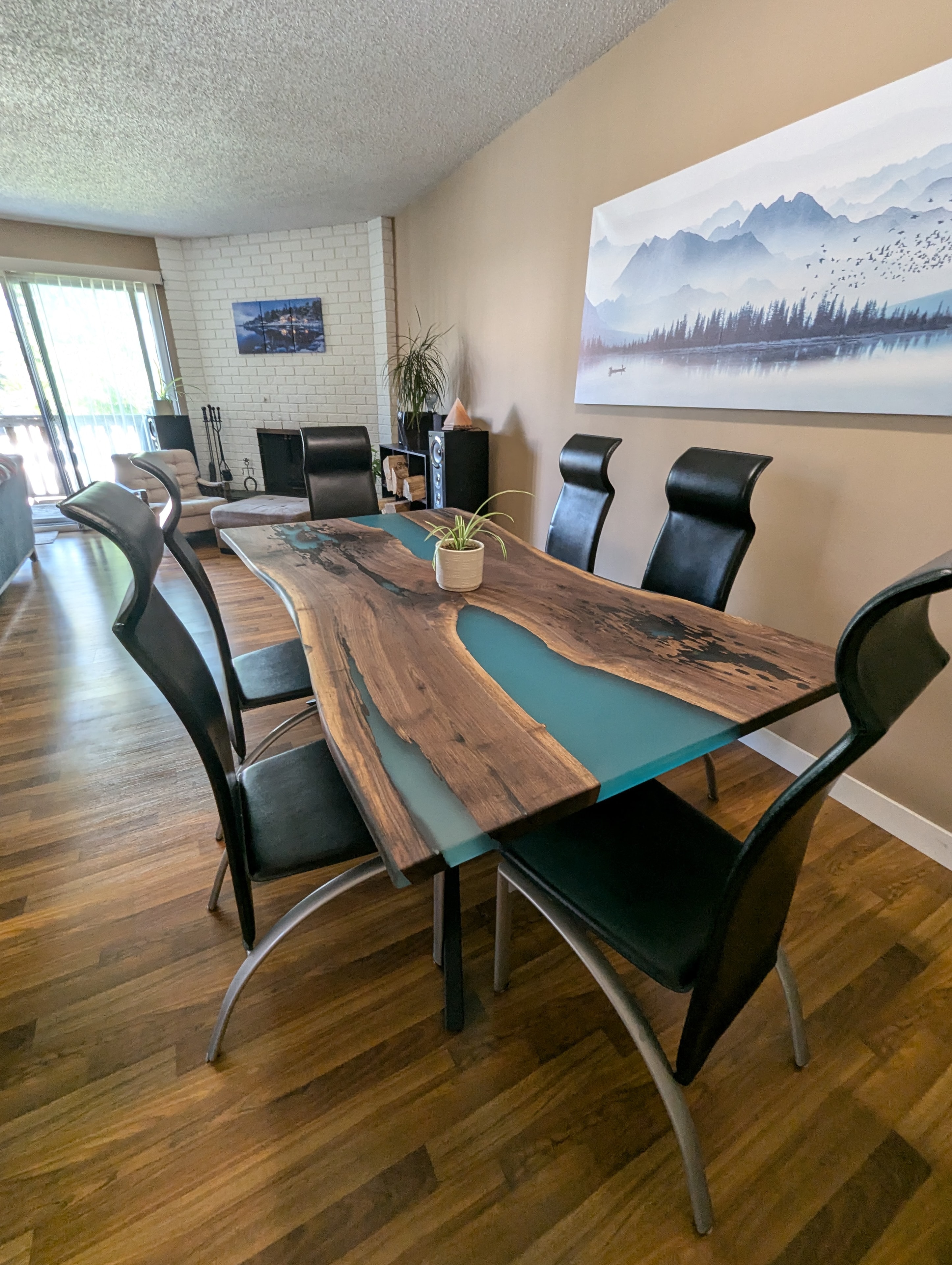 Live edge walnut blue metallic epoxy river dining table with navy chairs