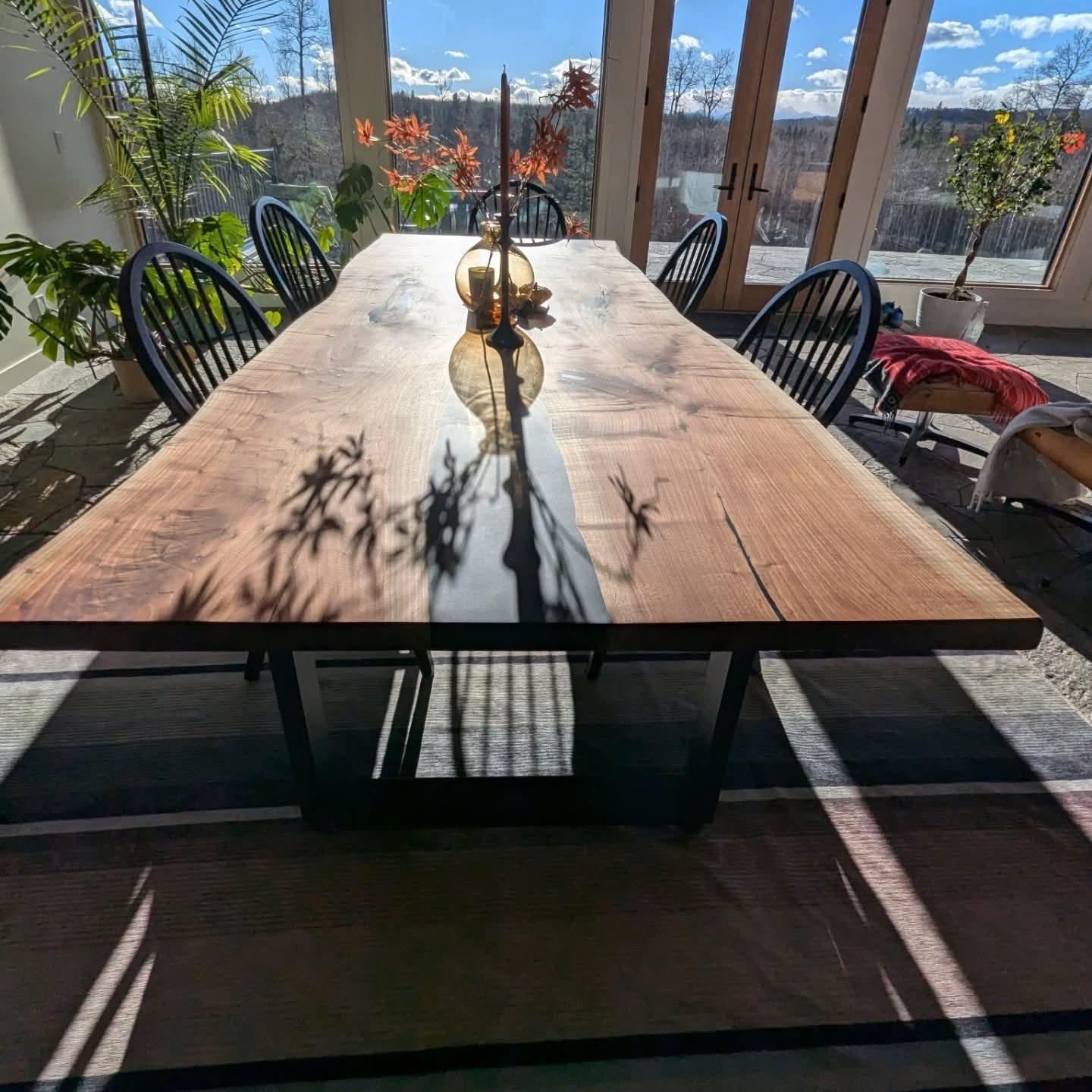 Clear epoxy walnut dining table with mountain view — Calgary