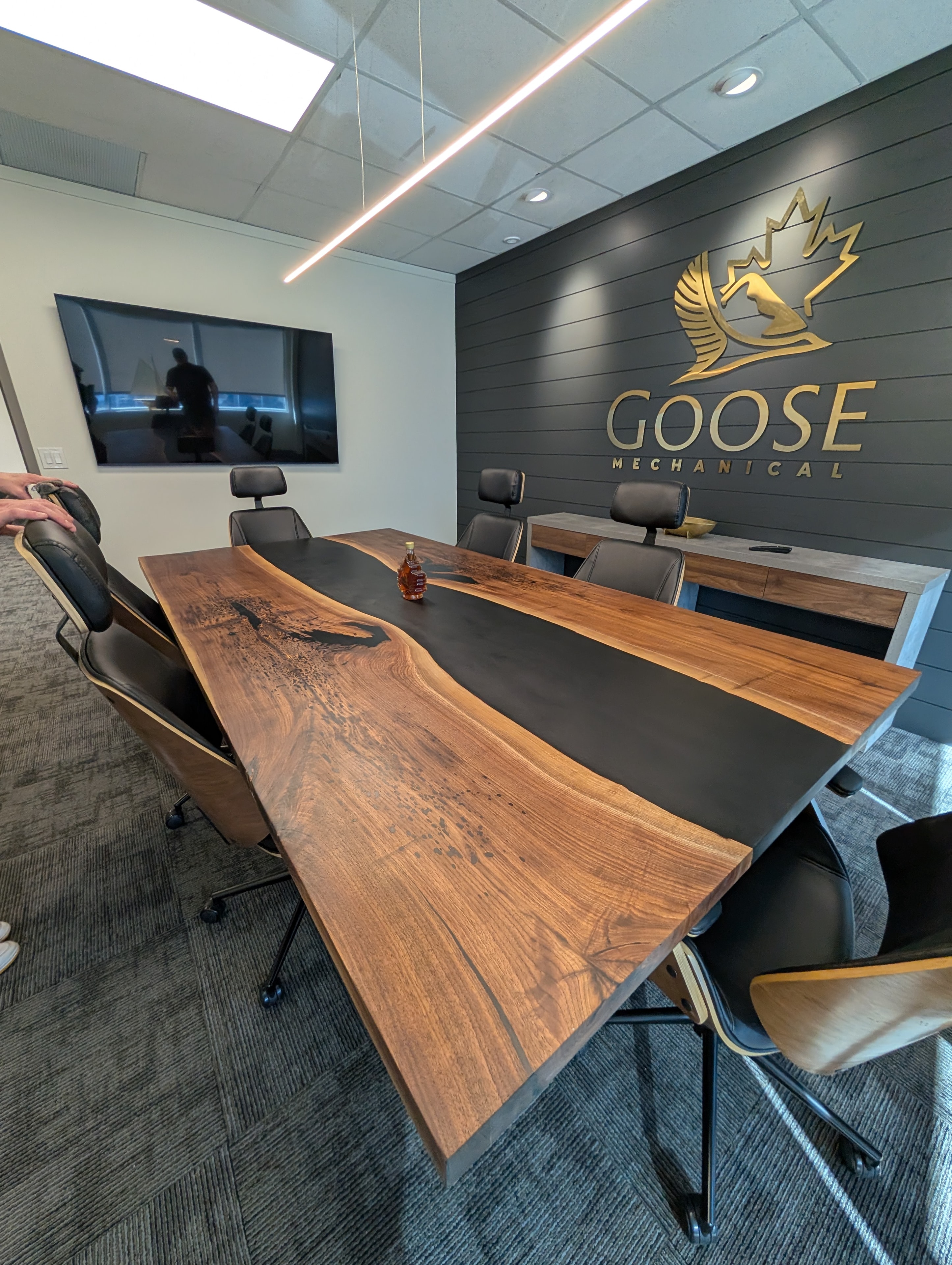 Live edge walnut black epoxy river conference table with matching credenza at Goose Mechanical Calgary