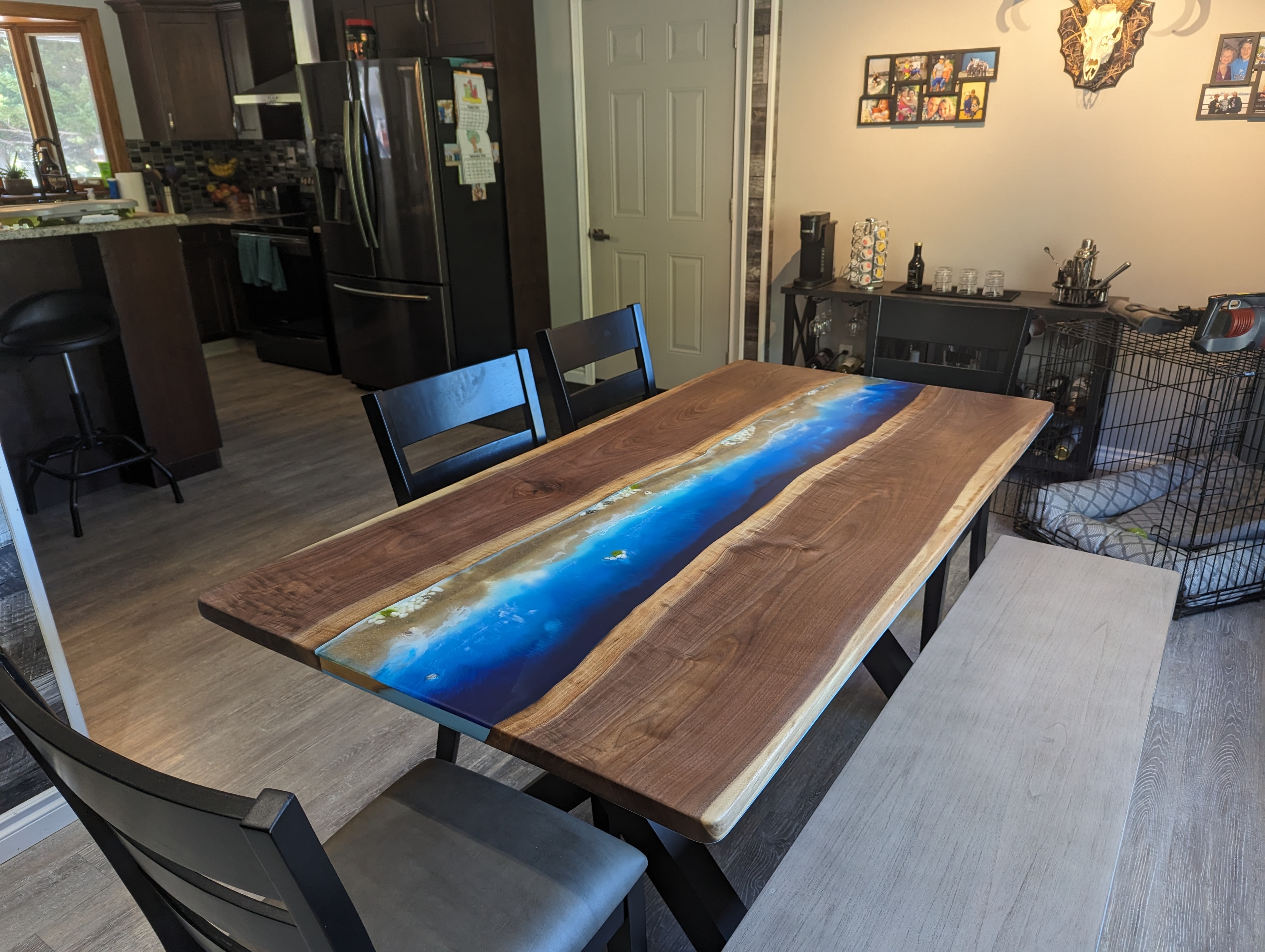 Walnut ocean blue epoxy river dining table with black A-frame base and dark chairs