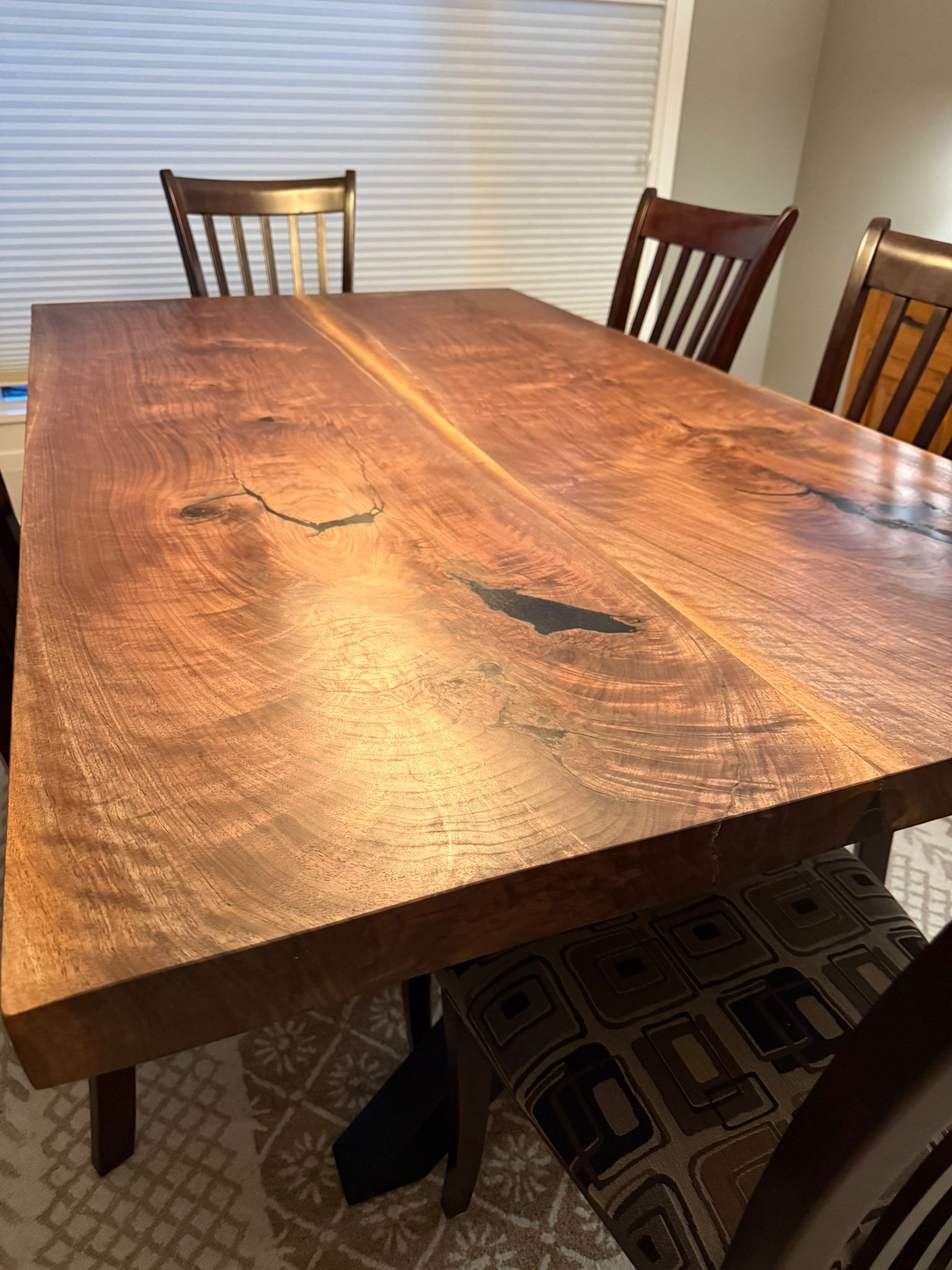 Solid walnut bookmatched dining table with black epoxy void fills and traditional chairs