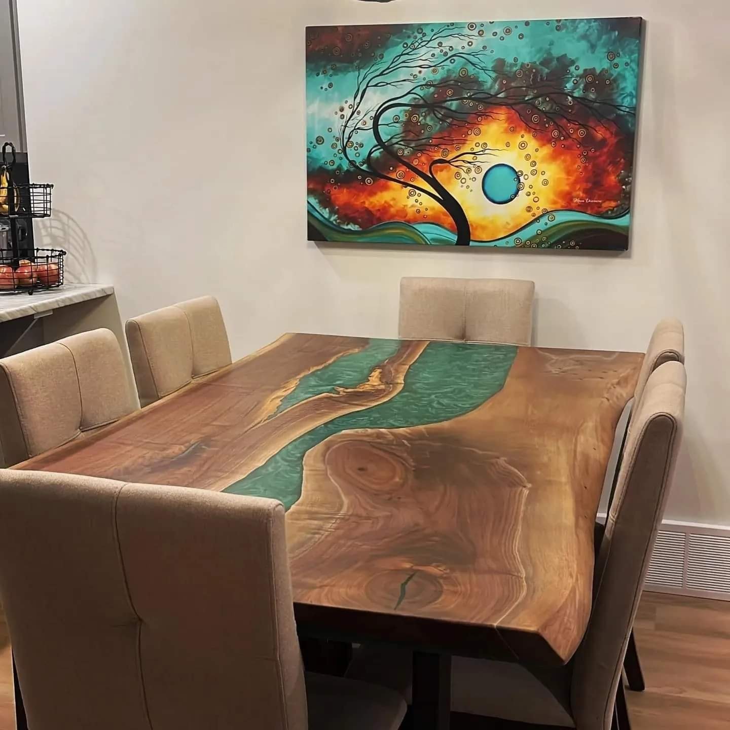 Live edge elm teal epoxy river dining table with linen chairs and abstract wall art