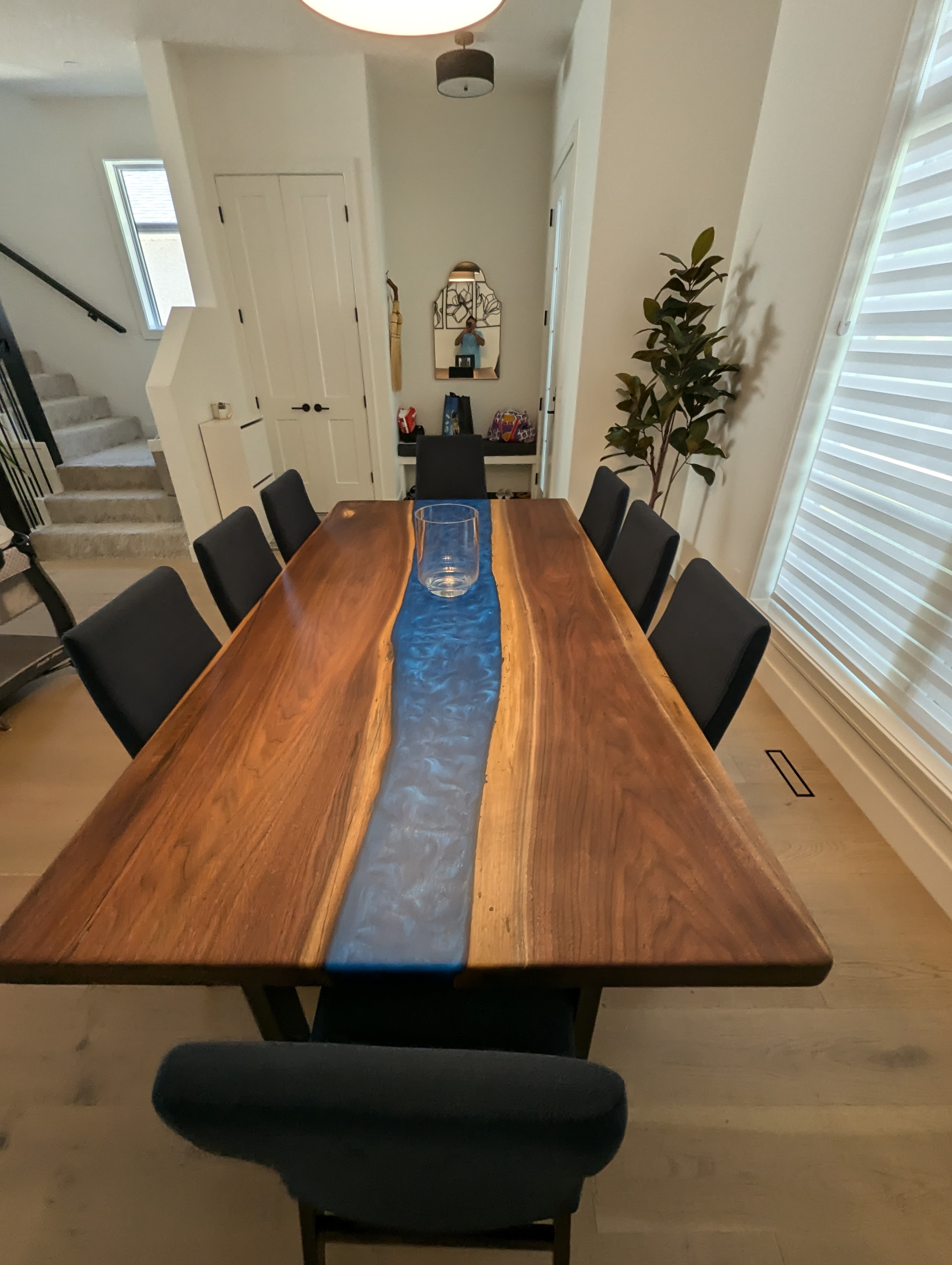Live edge walnut turquoise epoxy river dining table with black leather chairs
