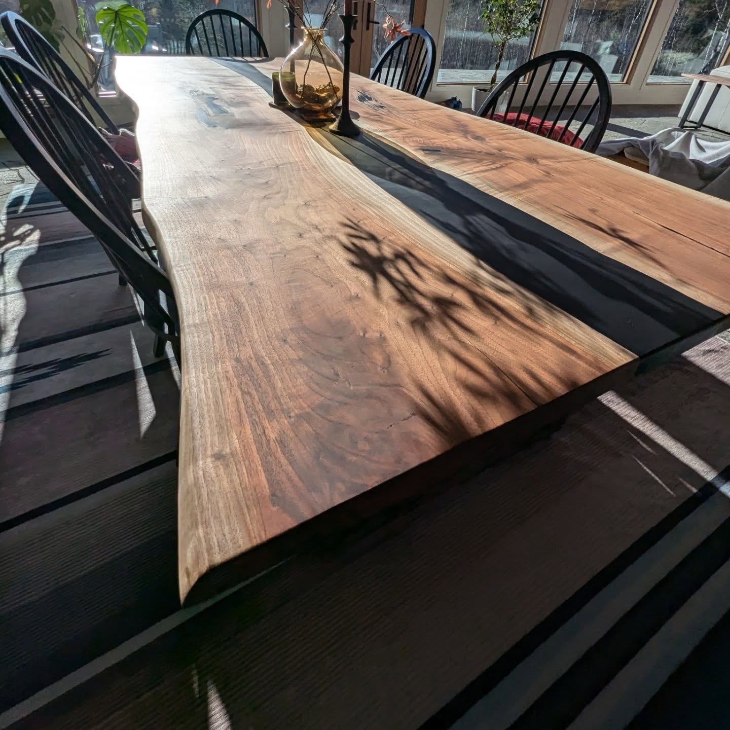 Live edge walnut slab with lightning-bolt blue epoxy crack fills — overhead shop view at Calgary Wood Works