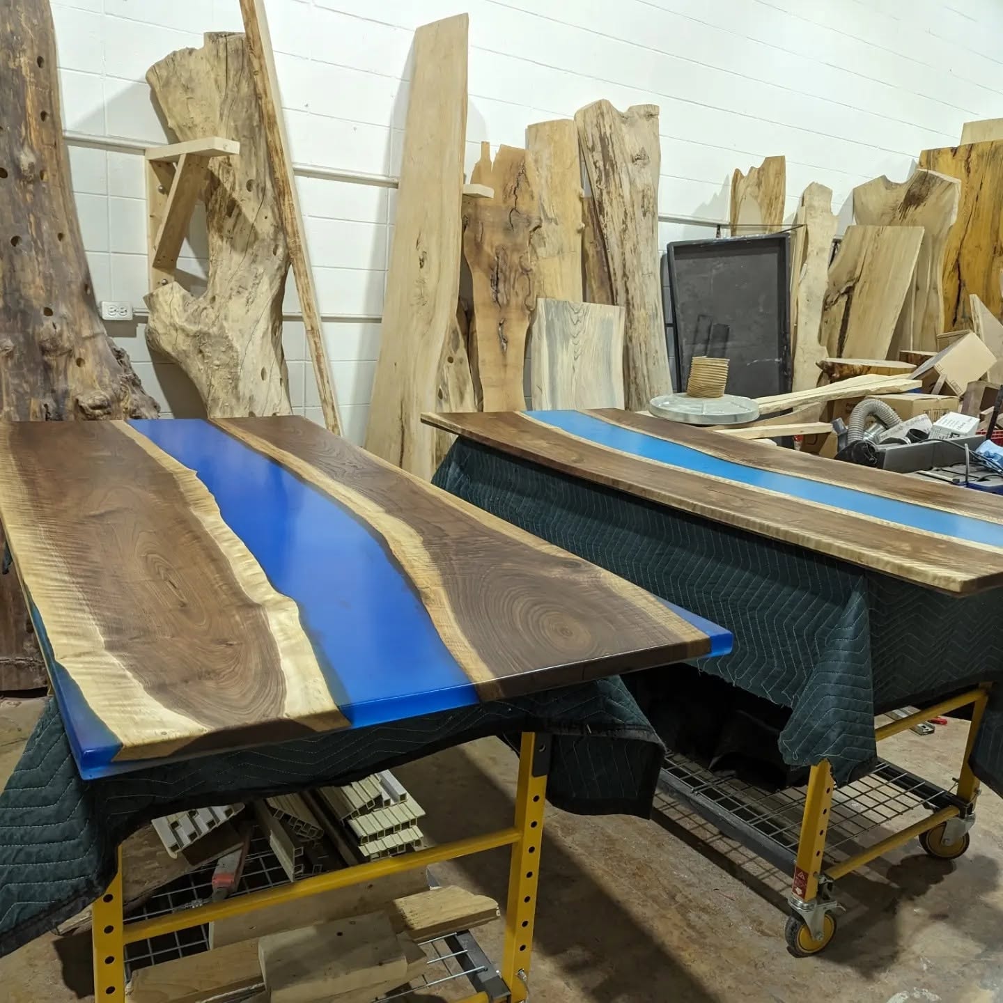 Two live edge walnut blue epoxy river dining tables in production — Calgary Wood Works shop batch