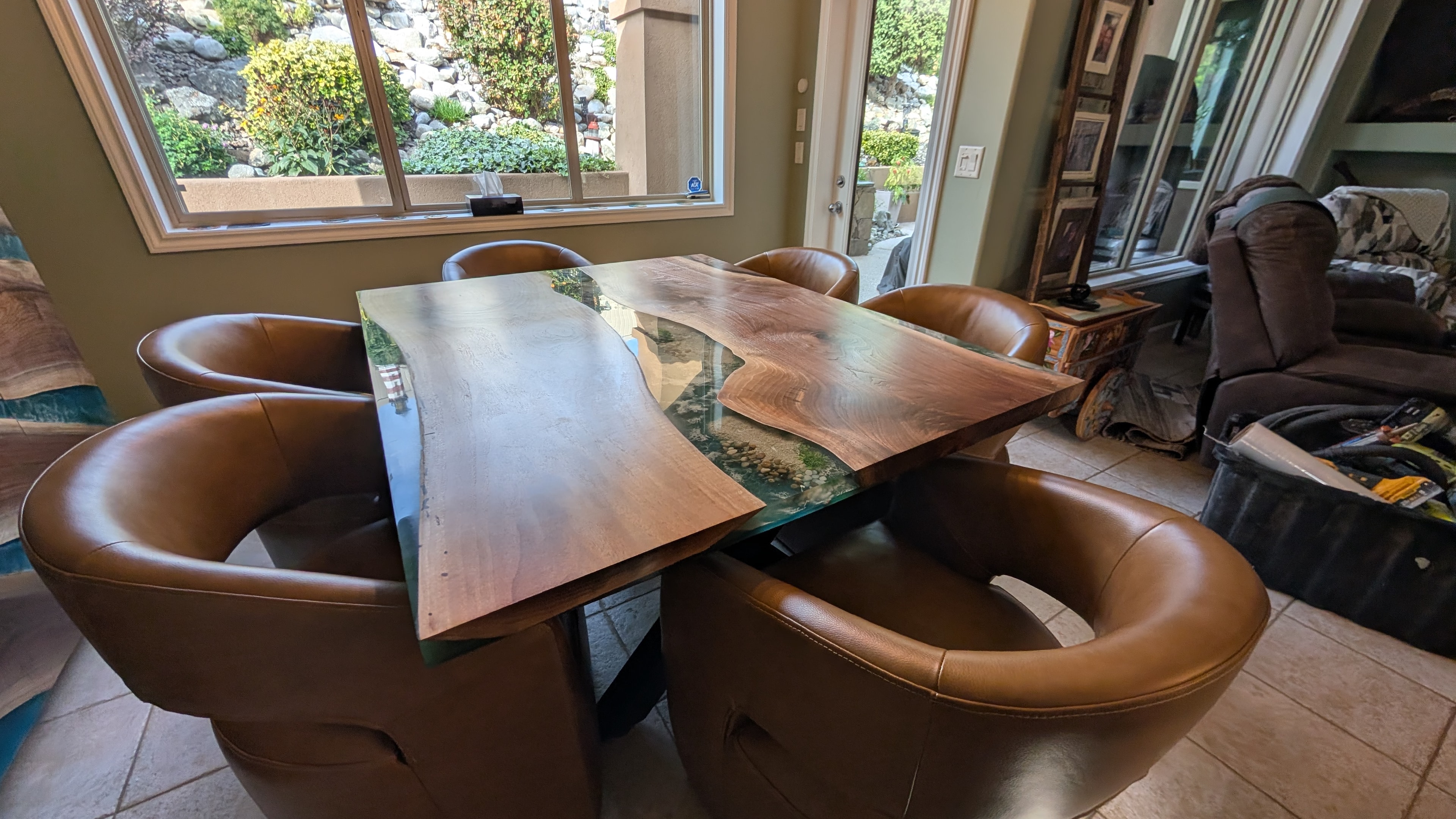 Spalted maple green epoxy river dining table on display at Calgary Wood Works showroom with art gallery backdrop