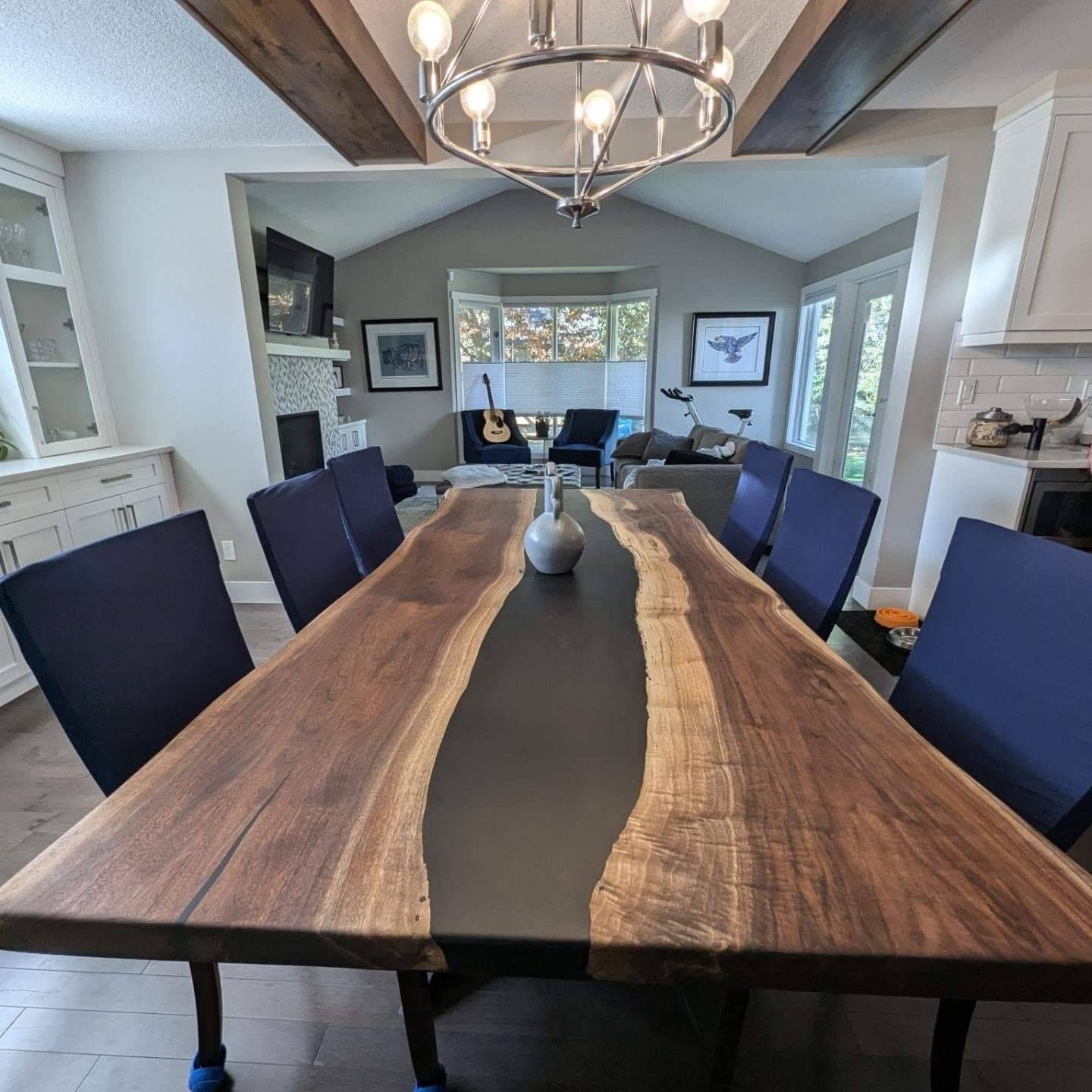 Live edge bookmatched walnut grey epoxy river dining table seating 10 with navy chairs — Calgary home with vaulted ceiling and chandelier