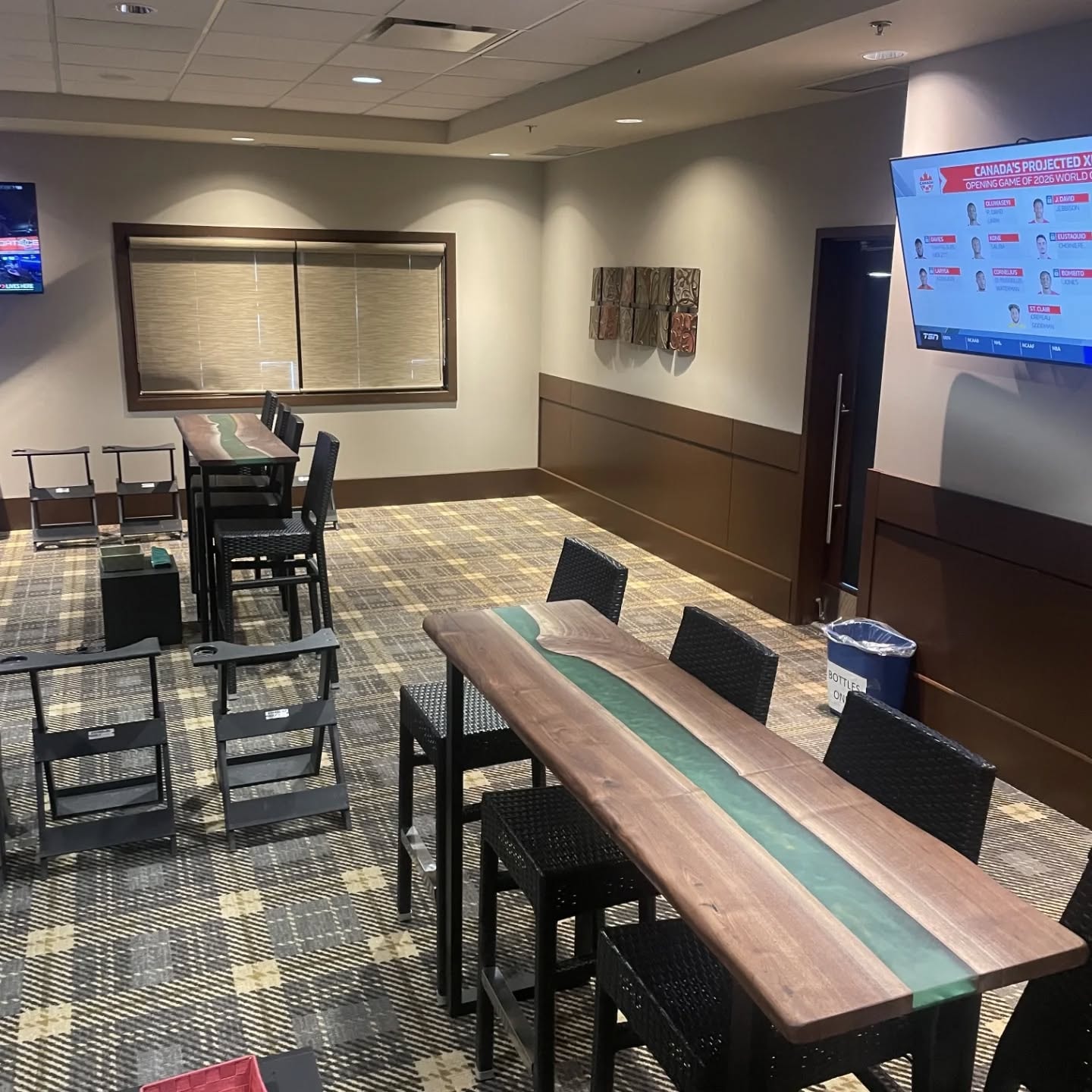 Custom walnut teal green epoxy river bar-height tables installed at Calgary sports venue — Calgary Wood Works