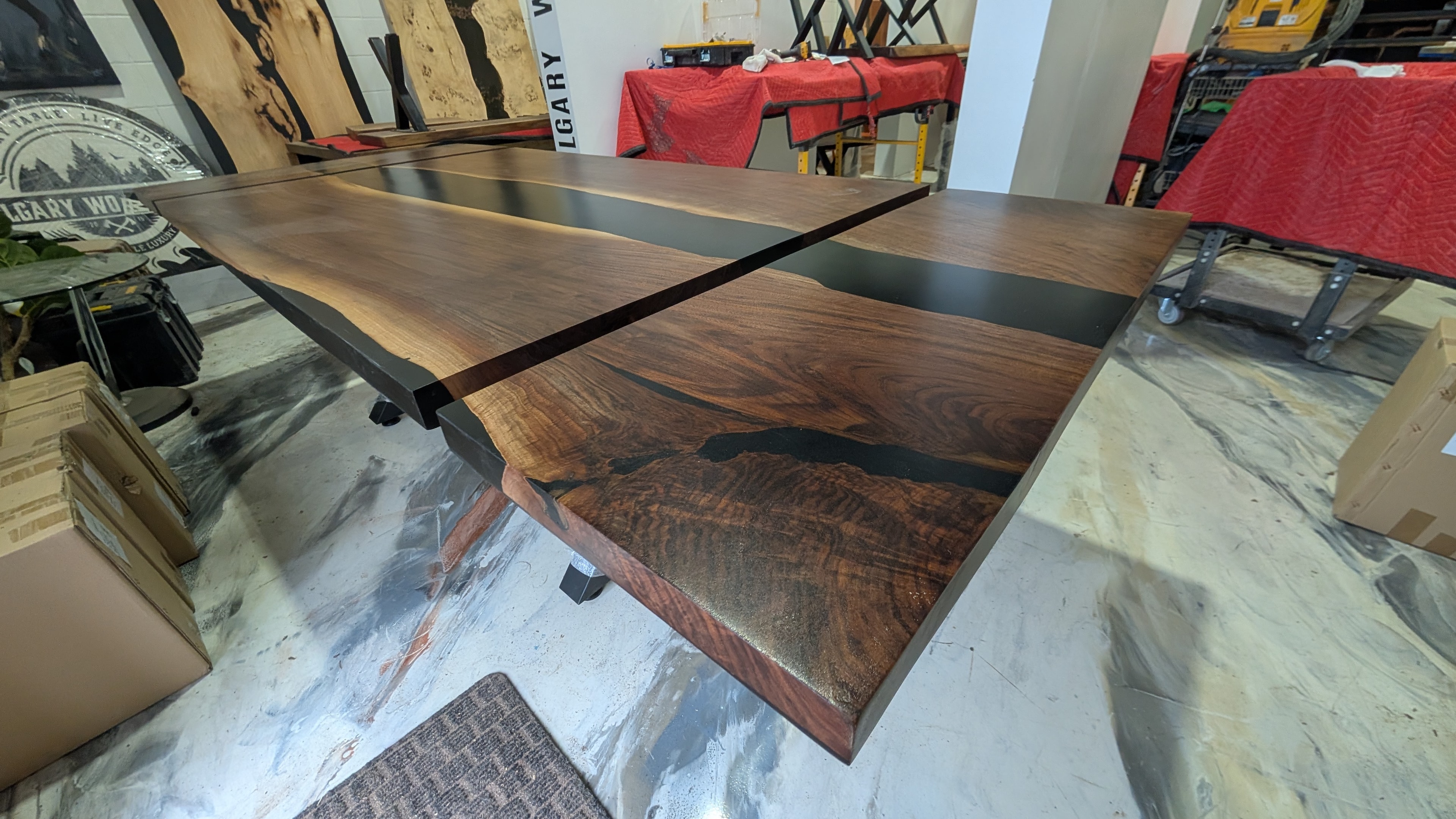 Custom expandable walnut black epoxy river dining table — extended view showing live edge slabs and extension leaf — Calgary Wood Works