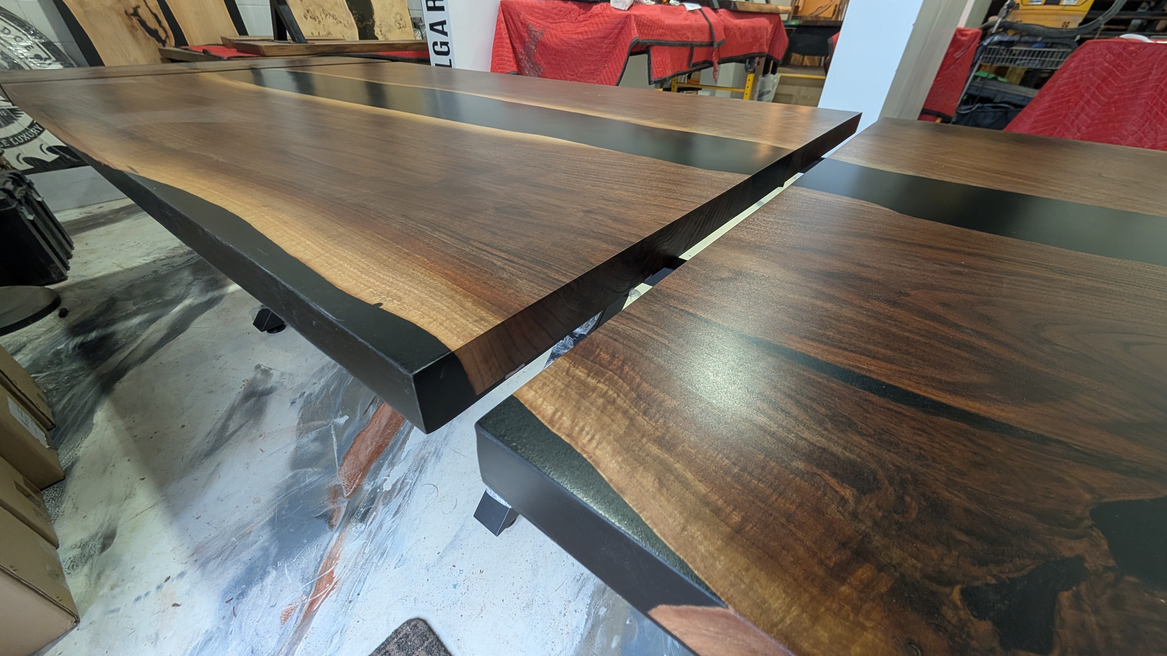 Custom expandable walnut black epoxy dining table — side angle showing extension leaf and live edge detail — Calgary Wood Works