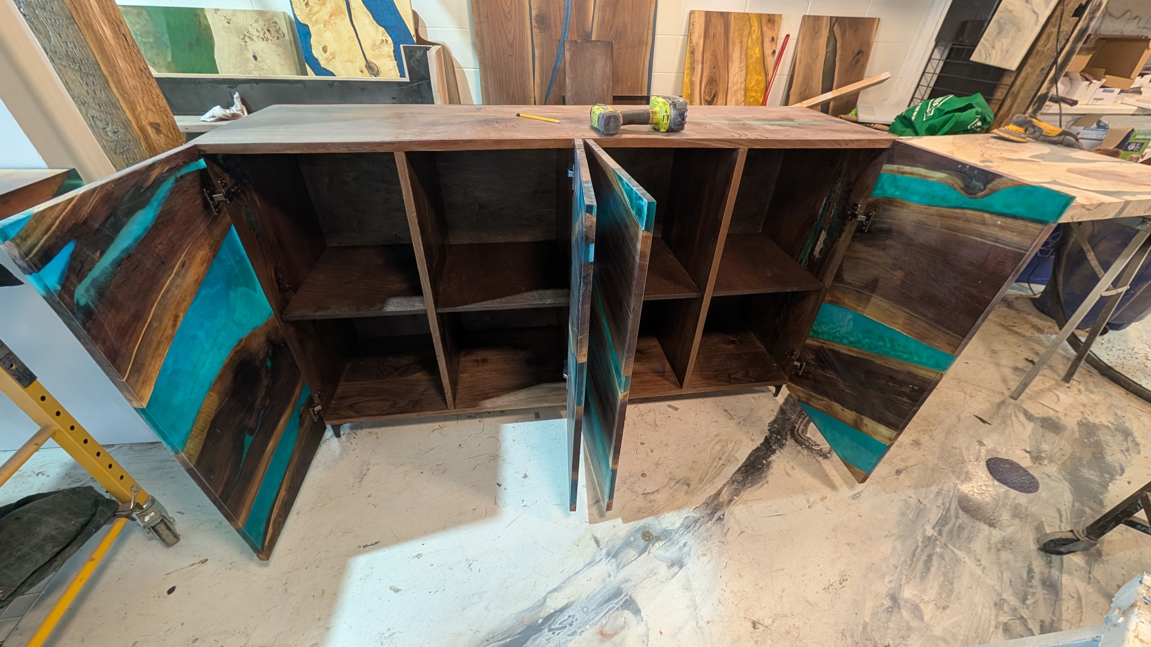 Custom walnut hutch with teal ocean epoxy doors open — interior shelving and storage revealed, Calgary Wood Works