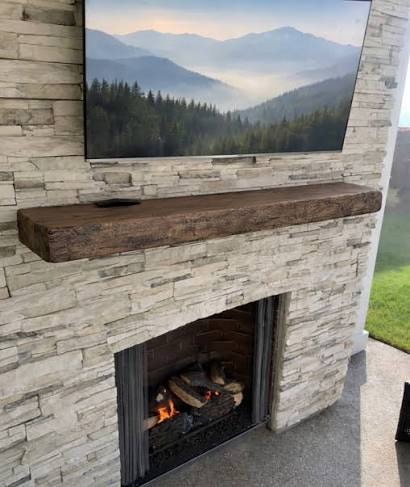 Live edge walnut fireplace mantel styled with candle, greenery and decorative bowl — Calgary Wood Works