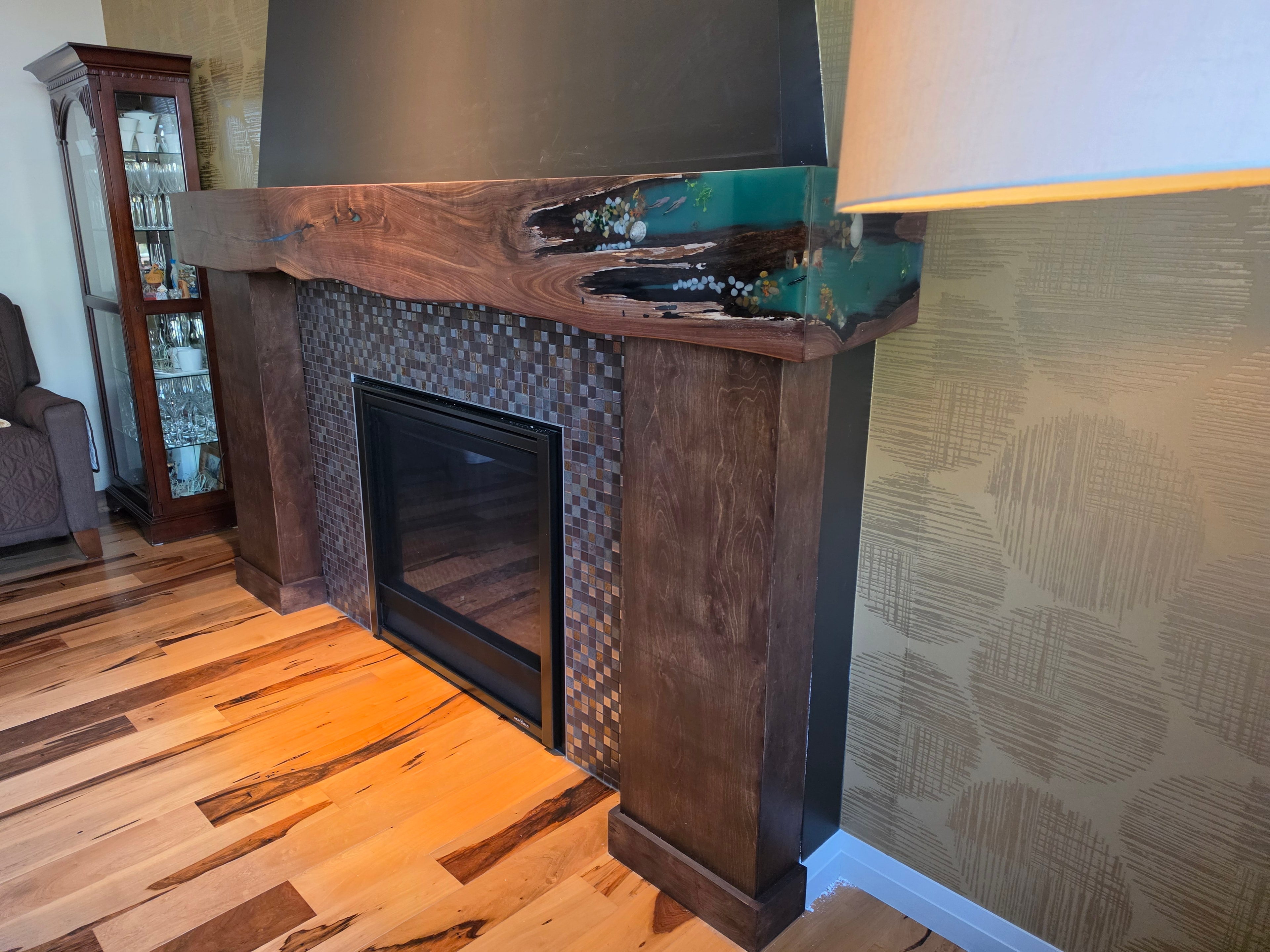 Walnut fireplace surround with teal epoxy resin detail — side angle view, Calgary Wood Works