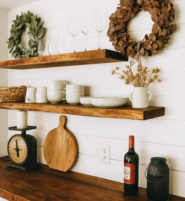 Rustic wood floating shelves on white shiplap kitchen wall styled with dishes and ceramics — Calgary Wood Works inspiration